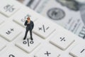 Miniature people business man standing and thinking on calculator percentage button using as FED consider interest rate, business Royalty Free Stock Photo