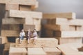 Miniature people : Business People sitting on wood block