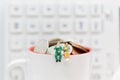 Miniature people : Business sitting on the glass and having a coffee break. Image use for food and beverage business concept