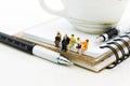 Miniature people : Business team sitting on book and having a coffee break. Image use for business concept Royalty Free Stock Photo