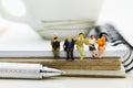 Miniature people : Business team sitting on book and having a coffee break. Image use for business concept Royalty Free Stock Photo