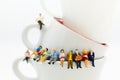 Miniature people : Business team sitting on cup of coffee and having a coffee break. Image use for business concept. Royalty Free Stock Photo