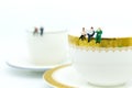 Miniature people : Business team sitting on cup of coffee and having a coffee break. Image use for business concept Royalty Free Stock Photo