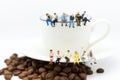 Miniature people : Business team sitting on cup of coffee and having a coffee break. Image use for business concept Royalty Free Stock Photo
