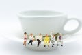 Miniature people : Business team sitting on cup of coffee and having a coffee break. Image use for business concept Royalty Free Stock Photo