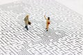 Miniature people: Business team standing on center of maze. Concepts of finding a solution, problem solving and challenge. Royalty Free Stock Photo