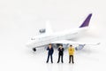 Miniature people: Business team standing in front of airplane. B Royalty Free Stock Photo