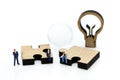 Miniature people : Businessman with jigsaw and idea lamp using f