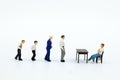 Miniature people: Businessman looking for employees for job placement. Image use for choice of the best suited employee, job Royalty Free Stock Photo