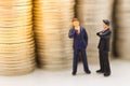 Miniature people, Businessman looking for stack of coins using as background money growth up, saving, financial, business concept Royalty Free Stock Photo