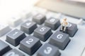 Miniature people: Businessman reading on calculator. Financial and business concept.