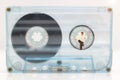 Miniature people: Businessman reading newspaper on tape Cassette Royalty Free Stock Photo