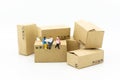 Miniature people : Businessman sitting on box in warehouse. Image use for business, industrial and logistic concept Royalty Free Stock Photo