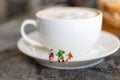 Miniature people: Businessman sitting with cup of coffee, image use for break time to charge energy during the day