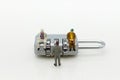 Miniature people: Businessman sitting on master key encoding. Image use for background security system, hack, business concept