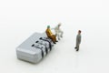 Miniature people: Businessman sitting on master key encoding. Image use for background security system, hack, business concept