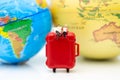 Miniature people : Businessman sitting on red suitcase, world map for background. Image use for travel, business concept Royalty Free Stock Photo