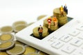 Miniature people: Businessman sitting on stack of coins with calculator, calculation tax monthly/yearly. Image use for Tax