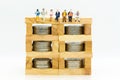 Miniature people: Businessman sitting on a wooden block to keep money bank. Image use for business concept