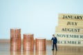 Miniature people: Businessman stack of coins with copy space