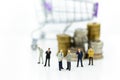 Miniature people: Businessman and stack of coins, shopping cart. Image use for online and offline shopping, marketing place world