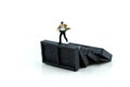 Miniature people : Businessman with Stack of dominoes falling ,business solution, strategy and successful intervention Royalty Free Stock Photo