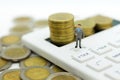 Miniature people: Businessman stand on calculator, calculation tax monthly/yearly. Image use for Tax calculation every year