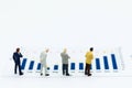 Miniature people: Businessman stand front of dashboard, display graphs, profit margins of background. Image use for business