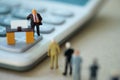 Miniature people businessman standing on calculator and talk to staff about salary and wage increase Royalty Free Stock Photo