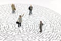 Miniature people: Businessman standing on center of maze. Concepts of finding a solution, problem solving and challenge. Royalty Free Stock Photo