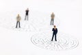 Miniature people: Businessman standing on center of maze and th Royalty Free Stock Photo