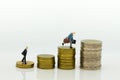 Miniature people : Businessman standing on a coin stacked increase up respectively. Image use for business concept. Royalty Free Stock Photo