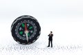 Miniature people : businessman standing with compass on maze paper. Image use for business concept Royalty Free Stock Photo