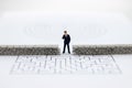 Miniature people: Businessman standing front of the wall and the world is inside. Image use for business security center, protect.