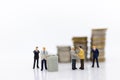 Miniature people: Businessman standing on the stack of coins. Image use for business concept