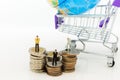 Miniature people: Businessman standing on stack of coins, shopping cart with world map for retail business. Image use for online