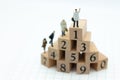 Miniature people : Businessman standing on wooden blocks with sequential numbers , win and loser. Image use for business concept