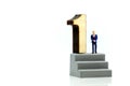 Miniature people : Businessman standing with wooden number of 1,to be the first,Business competition Concept.