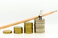 Miniature people: Businessman staning on the stack of coins. Image use for business concept