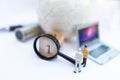 Miniature people: Businessman with  white globe and  laptop, use a magnifying glass to get number one. Recruitment finding Royalty Free Stock Photo