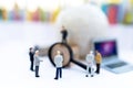 Miniature people: Businessman with  white globe and  laptop, use a magnifying glass to get number one. Recruitment finding Royalty Free Stock Photo