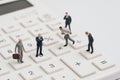 Miniature people businessmen figure standing on white calculator on white background using as teamwork ,business performance Royalty Free Stock Photo