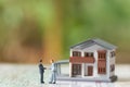 Miniature 2 people businessmen Shake hands with A model house model .as background business concept and real estate concept Royalty Free Stock Photo