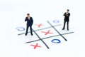 Miniature people: Businessmen stand on XO game board. Image use for business competition concept