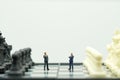 Miniature people businessmen standing on a chessboard with a che Royalty Free Stock Photo