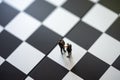 Miniature people businessmen standing on a chessboard with a che Royalty Free Stock Photo