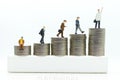 Miniature people : Businessmen standing on a coin stacked increase up respectively, used as a business concept Royalty Free Stock Photo