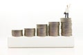 Miniature people : Businessmen standing on a coin stacked increase up respectively, used as a business concept Royalty Free Stock Photo