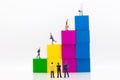 Miniature people : Businessmen standing and looking to graphs rise from business profits. Using as business concept