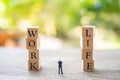 Miniature people businessmen standing with wood word WORK and LIFE using as background business concept and balance between life Royalty Free Stock Photo